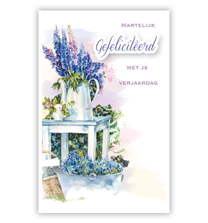Kan met paarse bloemen op tafel