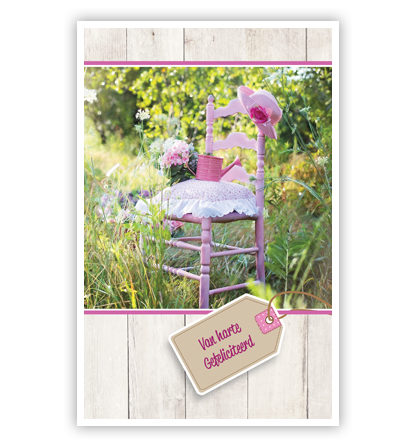Roze stoel met bloemen en gieter